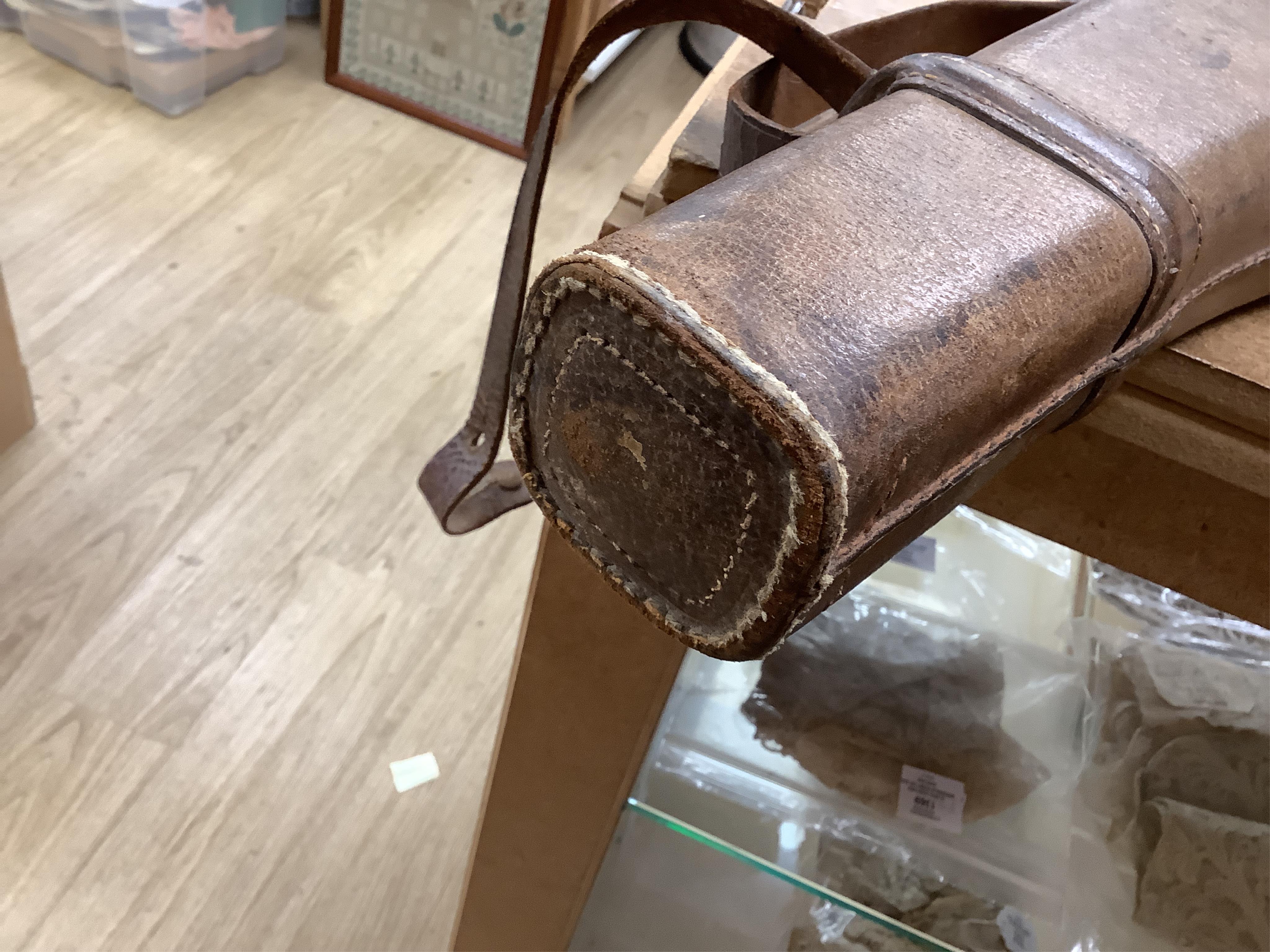 A 'Leg of Mutton' leather gun case and a top hat in leather case, gun case 75cm long.
